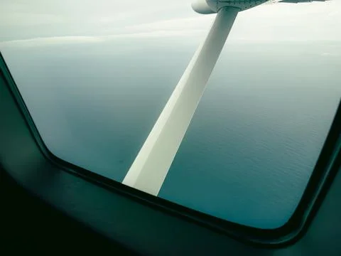 Airplane wing extends from the window frame Stock Photos