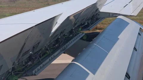 Airplane wing flaps and slats operation during landing from window view. Stock Footage 331784245