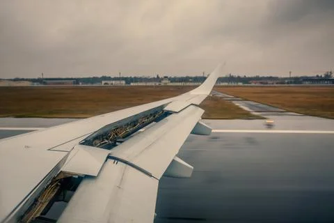 Airplane Wing With Flaps Extended During Rainy Takeoff Over Wet Runway Airport Stock Photos