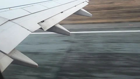 Airplane wing with flaps extending, moving swiftly along the tarmac, capturing Vidéo 335266185
