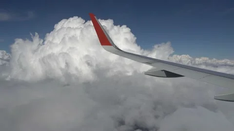 Airplane wing flies past a cloud. Cumulus cloud near the wing. View from the Stock Footage 165000661