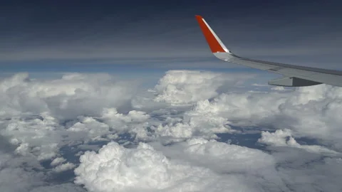 Airplane wing flies past a cloud. View from window of plane. Cumulus cloud near Stock Footage 165952546