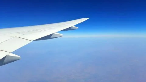 Airplane Wing in Flight Above Clouds Stock Photos