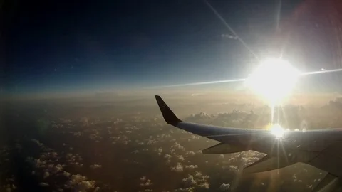 Airplane wing in flight with clouds and sun rising in background Vidéo 95833703