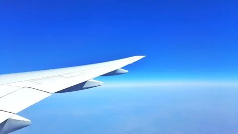 Airplane Wing in Flight Over Clouds Stock Photos