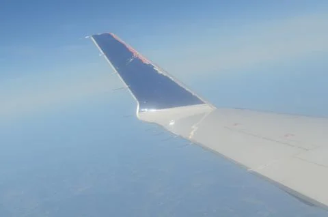 Airplane wing in flight. Photograph taken from inside the plane. Stock Photos