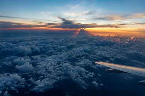 Airplane Wing in Flight from window, sunset sky Stock Photos