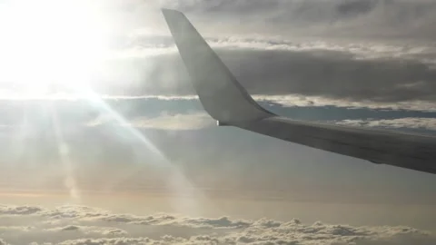 Airplane wing flying above the clouds with sun Stock Footage 339353122