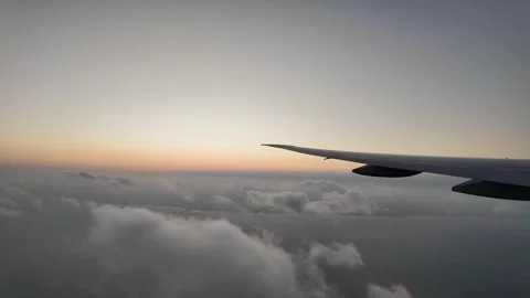 Airplane wing flying above clouds at sunrise Stock Footage 345995506