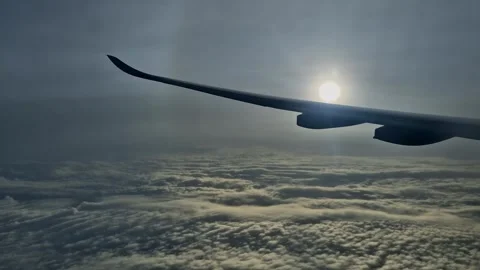 Airplane Wing Flying Above Clouds Towards Bright Sun With Lens Flare Stock Footage 346600224