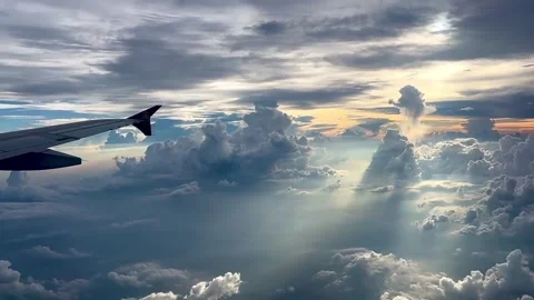 Airplane Wing Flying Above Dramatic Clouds with Sun Rays at Golden Hour Video stock 337111104