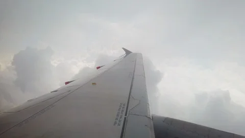 Airplane wing flying over clouds Stock Footage 123554083