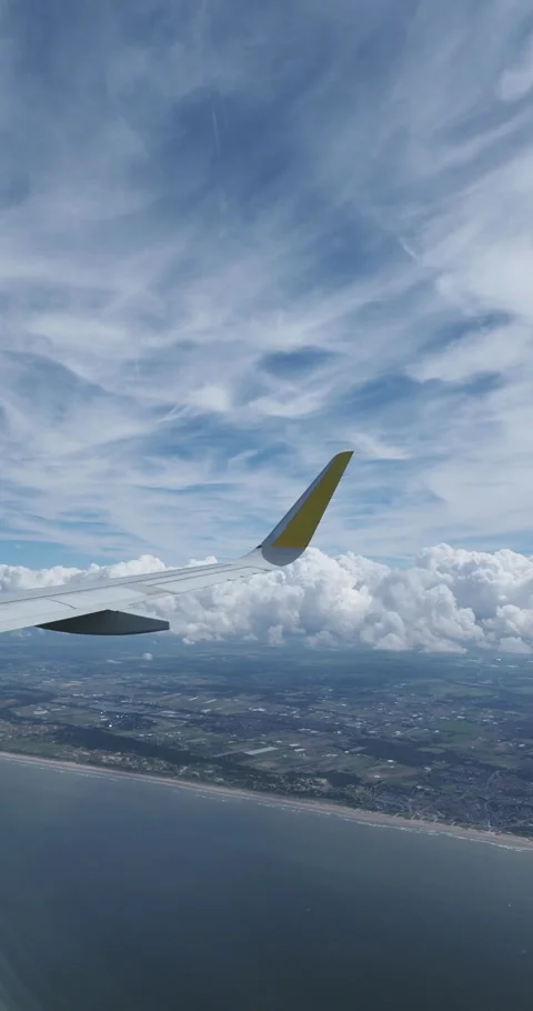 Airplane wing flying over clouds and coastline Stock Footage 300618962