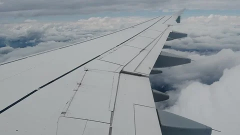 Airplane wing flying through clouds during landing approach Stock Footage 345127368