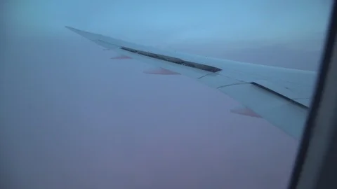 Airplane wing going through pink clouds Stock Footage 106591643