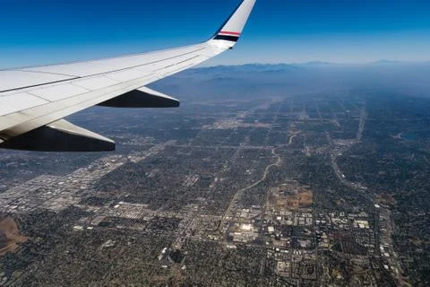 Airplane wing over the city Stock Photos