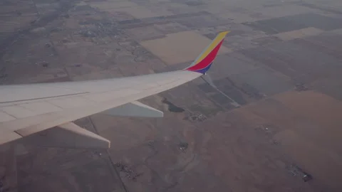 Airplane wing over patchwork farmland after takeoff from Denver Stock Footage 348791332