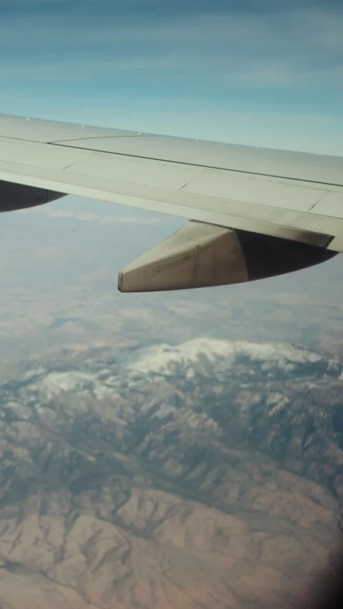 Airplane wing over snow capped mountain range in winter Stock-Footage 347966493