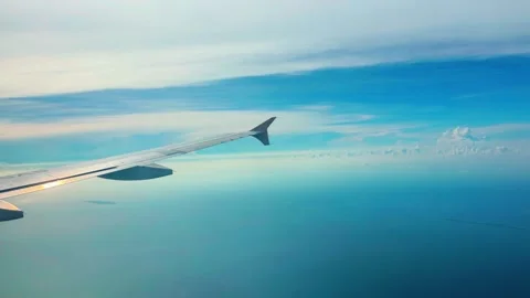 Airplane wing perspective during high altitude flight over vast blue ocean .. 스톡 동영상 333840493