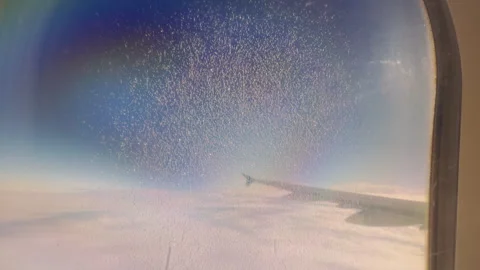 Airplane Wing seen through Window with Dense Droplet Pattern and Rainbow Tint in Stock Footage 323638565