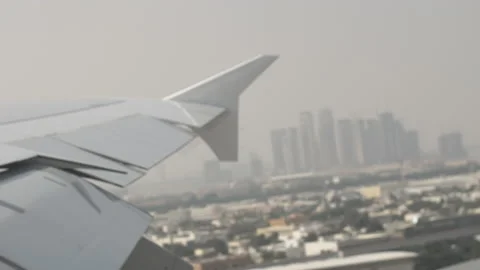 Airplane wing shot flying over Dubai City Landscape window shot Stock Footage