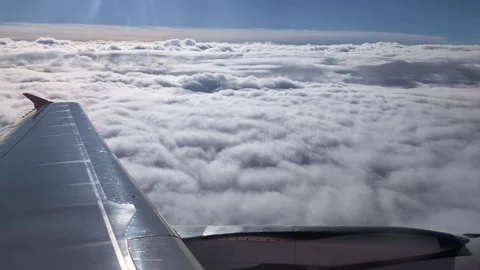 An airplane wing is shown gliding smoothly through a dense layer of clouds. Video stock 288072624