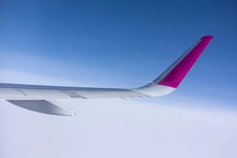 Airplane wing in the sky, view from the window Stock Photos