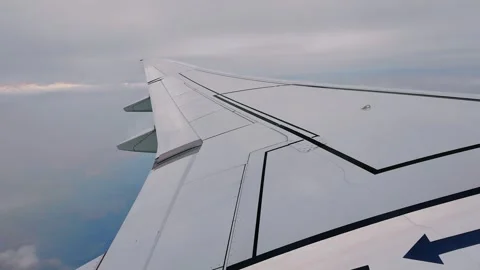 Airplane wing slicing through thick clouds during a daytime flight Stock Footage 316270165