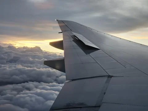Airplane wing at sunset above clouds during flight to Buenos Aires Fotos de archivo