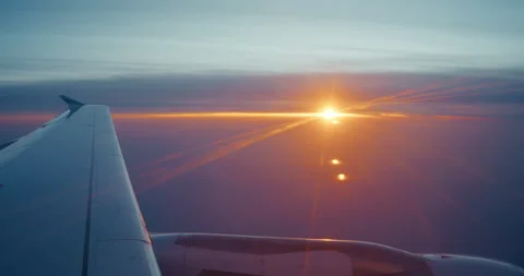 Airplane Wing at Sunset with Orange Sun Shining Through Clouds Stock Footage 343594156