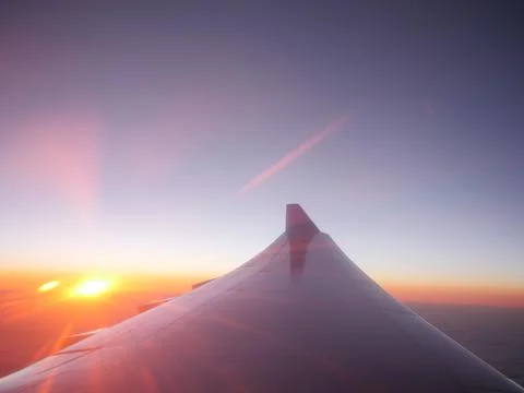Airplane wing at sunset Stock Photos
