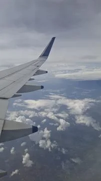 Airplane Wing View Above Clouds During Flight Over Ocean Stock Photos
