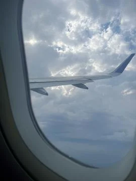Airplane Wing View Above Clouds from Passenger Window Stock Photos