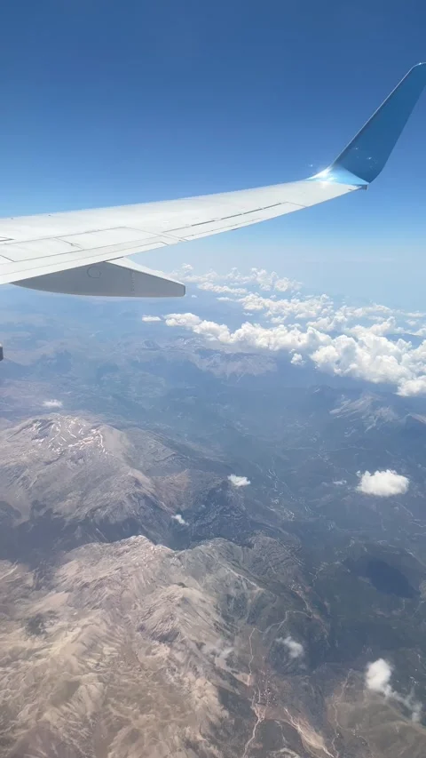 Airplane wing view above mountain ranges and clouds.  库存影片 339763833