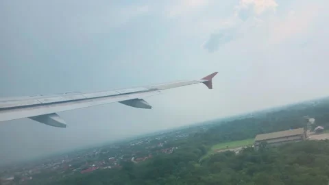 Airplane wing view capturing diverse landscapes from takeoff to high altitude Stock-Footage 333839051