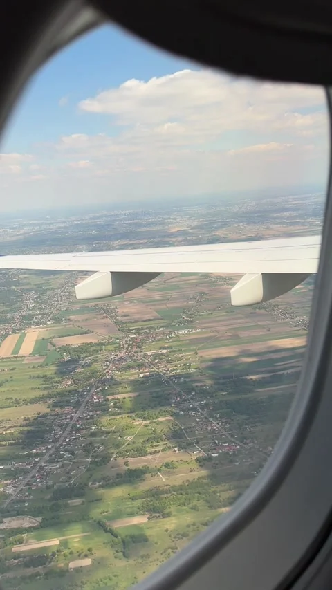 Airplane wing view during descent over patchwork fields and suburbs in Poland Video stock 310677525