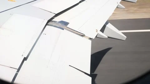 Airplane wing view during takeoff with wing flaps operating from a passenger Stock Footage 339353199