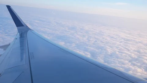 Airplane Wing View of Fluffy Clouds During Early Morning Flight Stock Footage 268650958