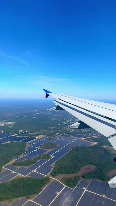 Airplane Wing View Flying Over Solar Farm with Clear Blue Skies Stockbeeldmateriaal 333501217