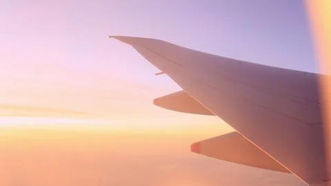 Airplane wing view out of the window the cloudy sunset sky background Stock Footage 120737188