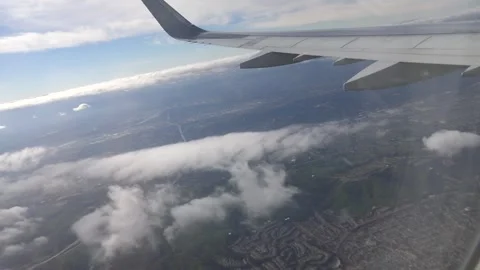 Airplane Wing View Over Cityscape and Clouds Stock Footage 321583104