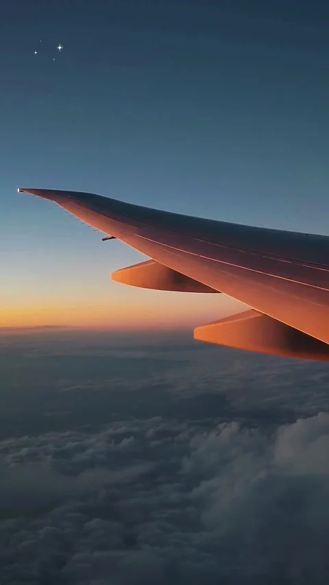 Airplane wing view over clouds at sunset, aerial travel footage from the sky. Stock Footage 342096652