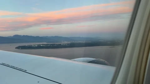 Airplane Wing View over Coastline and Pink Sky Stock Footage 346665212