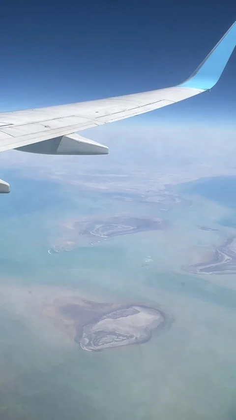 Airplane wing view over sea, with clouds and a blue sky.  Vídeos de archivo 339763837