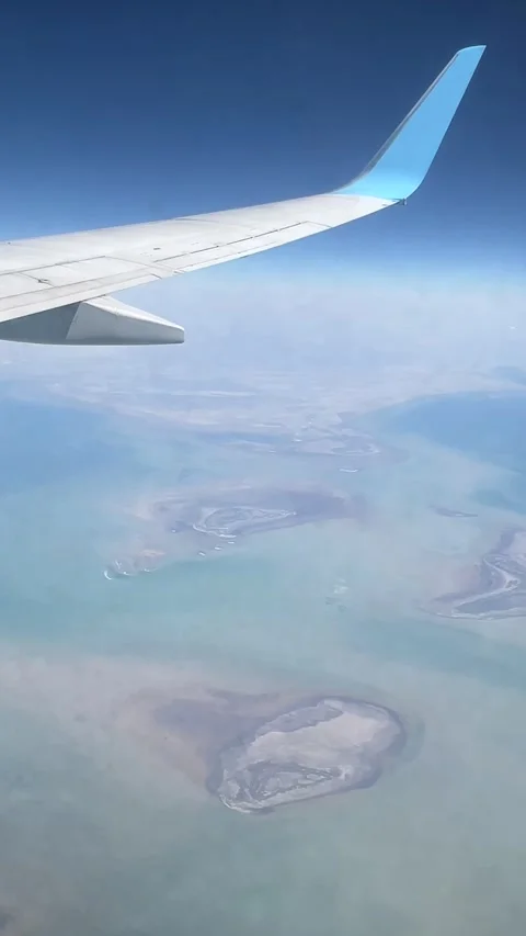 Airplane wing view over sea, with clouds and a blue sky.  動画素材 339763843