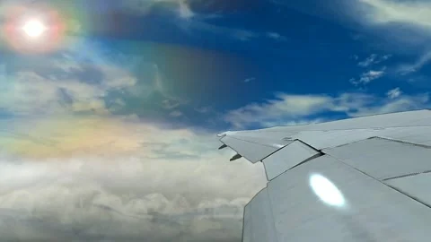 Airplane wing view with rainbow and clouds in the sky Stockbeeldmateriaal 335273396