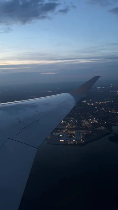 Airplane Wing View Through Passenger Window After Sunset. Dusk Evening Over Smal Stock Footage 345016195