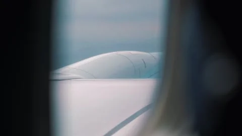 Airplane wing viewed through window during flight, showcasing the smooth surface Vídeo Stock 328481008