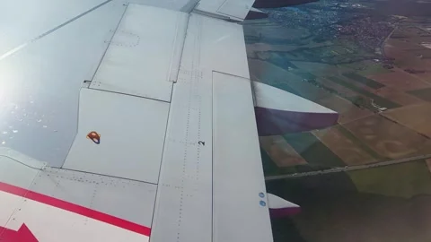 Airplane wing with visible flaps and wingtip light during descent Stock Footage 340665984