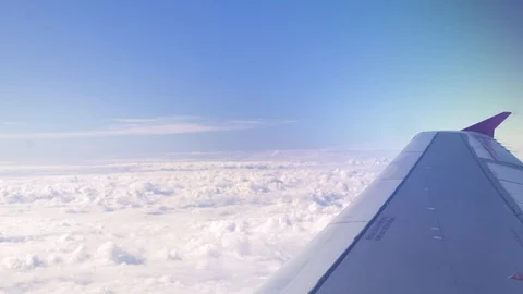 Airplane wing on white clouds and blue sky landscape. View from window flying Video stock 104963154